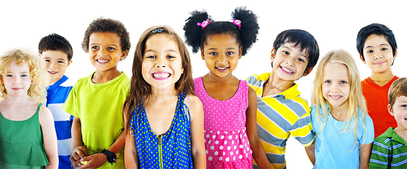 A group of diverse children posing for a photo with smiles, displaying various skin tones and styles.